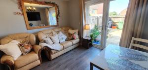 a living room with a couch and a mirror at Caspian House (4 Bedrooms) in Grimsby