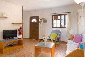 ein Wohnzimmer mit Sofa und Fernseher in der Unterkunft Holiday Cottage Santa Lucía 1 in Santa Lucía
