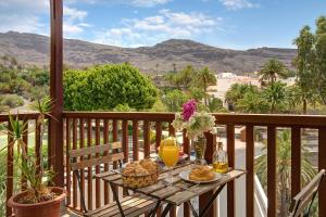 a table with food and drinks on a balcony at Holiday Cottage Santa Lucía 1 in Santa Lucía