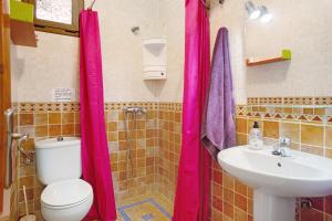 ein Badezimmer mit rosa Duschvorhängen, einem WC und einem Waschbecken in der Unterkunft Holiday Cottage Santa Lucía 2 in Santa Lucía + 21 Fotos