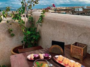 una mesa con 2 platos de comida en el balcón en Riad Moulaydriss et Giacomo, en Fez