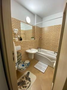 uma casa de banho com uma banheira, um lavatório e um WC. em Magic Belleview Sinaia em Sinaia