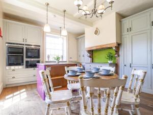 kuchnia z drewnianym stołem i krzesłami w obiekcie Solton Manor w mieście Dover
