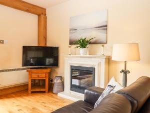 a living room with a couch and a fireplace at Dovecote in Dover