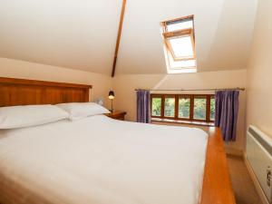 um quarto com uma cama grande e uma janela em Dovecote em Dover