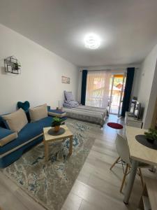 uma sala de estar com um sofá azul e uma mesa em Magic Belleview Sinaia em Sinaia