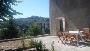 - une table et des chaises sur une terrasse avec vue dans l'établissement Maison des champs Elysées le Puy-en-Velay, à Chadrac