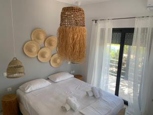 1 dormitorio con 1 cama con sábanas blancas y ventana en Villa sun gold Lagonisi en Áyios Nikólaos