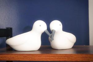 two white statues of birds on a table at Dumfries Apartment in Dumfries