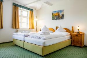 two twin beds in a room with a window at Hotel & Restaurant Brauner Hirsch Osterwieck in Osterwieck