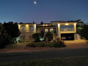 une grande maison la nuit avec la lune dans le ciel dans l'établissement Protea Suite, à Bellville