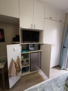 a kitchen with a refrigerator and a tv at Protea Suite in Bellville