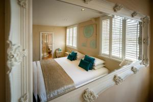a bedroom with a large bed with green pillows at The White Swan Hotel Bar & Restaurant in Henley in Arden