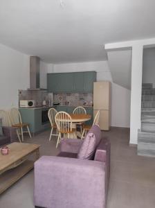 een woonkamer met een paarse bank en een tafel bij Cosy in Kardamaina