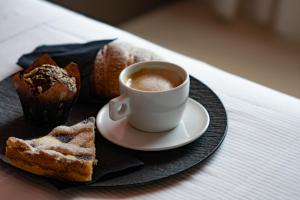 斯佩隆加的住宿－La Maison - Boutique Rooms，一杯咖啡和一盘面包
