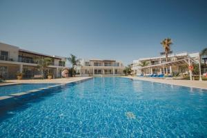 a large blue swimming pool with buildings in the background at Трехкомнатные апартаменты в жилом комплексе Caesar Beach D2 Flat16 in Boğaz