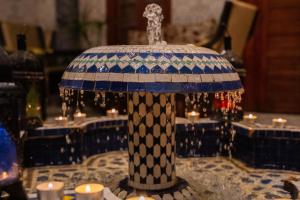 uma mesa coberta com um guarda-chuva sobre uma mesa com velas em Riad bel kayed em Fez