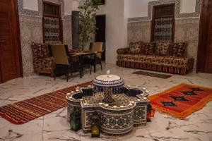a living room with couches and a table in the middle at Riad bel kayed in Fès