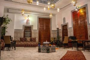 a living room with a couch and tables and chairs at Riad bel kayed in Fès