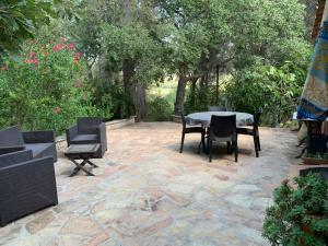 un patio con mesa, sillas y árboles en Bastidon CEZANNE en Aix-en-Provence