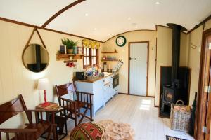 a kitchen and dining room with a table and chairs at Beech Shepherds Hut in Dittisham