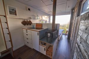 a kitchen with a stove in a tiny house at Swedish Treehouse 