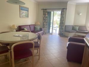 a living room with a couch and a table and chairs at Lovely 2 Bedroom Home inside a Resort in Albufeira in Albufeira