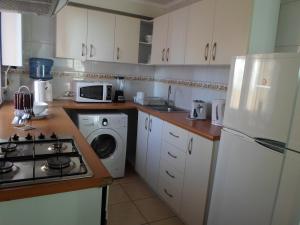 a kitchen with a white refrigerator and a washing machine at Departamentos Amoblados La Hermandad in Antofagasta