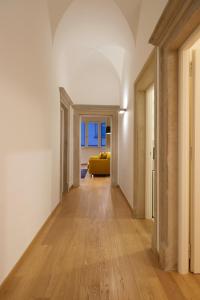 um corredor vazio com um sofá amarelo num quarto em Argentieri Apartment em Bolzano