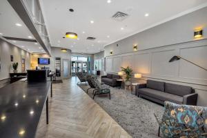 eine Lobby mit Sofas und eine Bar in einem Gebäude in der Unterkunft Sandman Hotel Grande Prairie in Grande Prairie