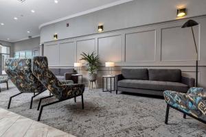 Sandman Hotel Grande Prairie في غراندي بريري: غرفة معيشة مع كرسيين وأريكة
