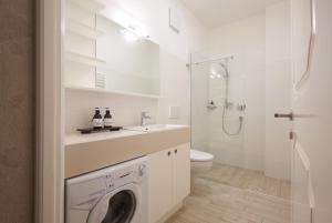 uma casa de banho branca com uma máquina de lavar roupa em Argentieri Apartment em Bolzano