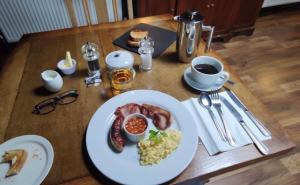 un tavolo con un piatto di prodotti per la colazione di The New Court Inn a Usk