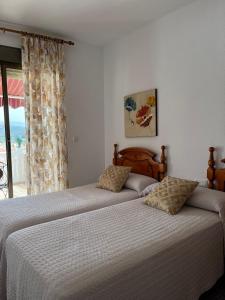 two beds sitting next to each other in a bedroom at Pensión Mari Carmen in Salobreña
