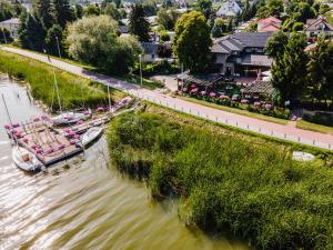 a boat is docked in the water next to a river at Hotel Pod Kasztanami in Lublin +14 photos