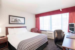 a hotel room with a bed and a desk at Sandman Hotel Penticton in Penticton