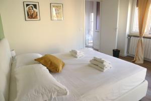 ein weißes Bett mit Handtüchern darüber in der Unterkunft Santa Maria Novella - Golden Lily Florence, city center apartment in Florenz