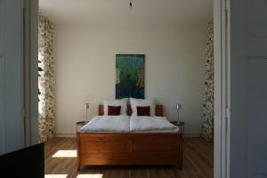 a bedroom with a bed with two red pillows at Rosalinde in Lüneburg
