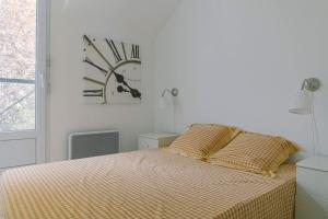 um quarto com uma cama com um relógio na parede em Luka's charming apartment near Disneyland em Magny-le-Hongre