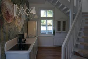 a kitchen with a sink and a staircase with a window at Rosalinde in Lüneburg