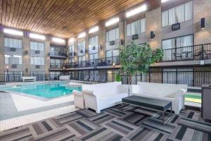 a hotel lobby with a pool and chairs at Sandman Hotel & Suites Kelowna in Kelowna