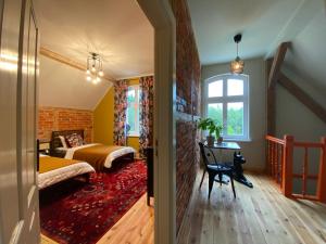 1 dormitorio con cama, escritorio y ventana en Siedlisko Jesionna, en Rakowiec