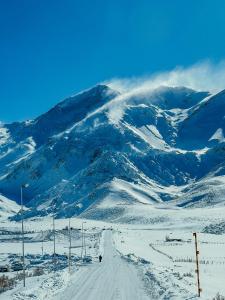 una montaña cubierta de nieve con una carretera delante de ella en Mountain Aparts Cirrus en Las Lenas