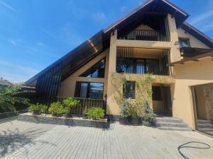 阿尔杰什河畔库尔泰亚Pensiunea Relax的前面有盆栽植物的房子