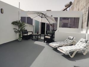 un patio al aire libre con sillas y sombrilla en Lanzalina, en Arrecife
