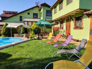 Villa Real Paradise في سميزاني: مجموعة من الكراسي جالسة على العشب بجوار المنزل
