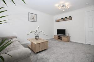 uma sala de estar com um sofá e uma televisão em Katie's house em Cumbernauld