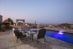 a group of chairs sitting next to a swimming pool at Des & Coo Luxury Villa with Private Pool in Faliraki
