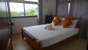 um quarto com uma cama com almofadas laranja e branca em Belle Rose Vue guest house em Baie Sainte Anne mais 17 fotografias