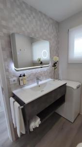 uma casa de banho com um lavatório, um espelho e um WC. em Marina Atico Penthouse em Puerto de la Cruz